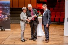  Dr. Nico Kock verleiht Sabine Schmidtseifer-Sürig (Gymnasium Holthausen, Hattingen), im Beisein von Dr. Carsten Penz, den Sonderpreis für die Projektbetreuenden. © RUB, Marquard