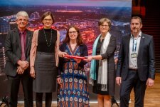 Prof. Dr. Katrin Sommer überreicht Dr. Ute Krupp, im Beisein von Sabine Timmermann, Dr. Carsten Penz und Dr. Nico Kock, den Staffelstab für die Ausrichtung des NRW-Landeswettbewerbs von „Jugend forscht“ 2024. © RUB, Marquard